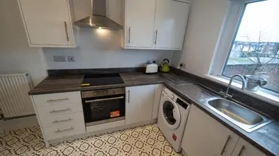 a kitchen with a sink and a washing machine at The road to Wigan Pier in Pemberton