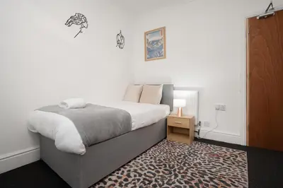 a bedroom with a large bed and a rug at Anfield Abbey House in Liverpool