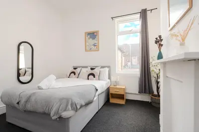 a bedroom with a bed with a mirror and a window at Anfield Abbey House in Liverpool