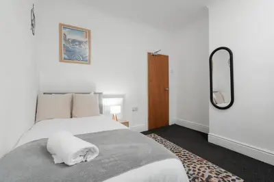 a bedroom with a white bed and a mirror at Anfield Abbey House in Liverpool
