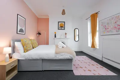 a bedroom with a bed and a pink wall at Anfield Abbey House in Liverpool