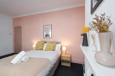 a bedroom with a bed and a vase on a table at Anfield Abbey House in Liverpool