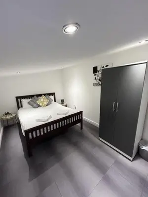 a bedroom with a bed and a large black cabinet at Bethel Suite by Sasco Apartments in Blackpool