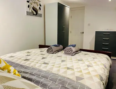 a bedroom with a large bed with towels on it at Bethel Suite by Sasco Apartments in Blackpool