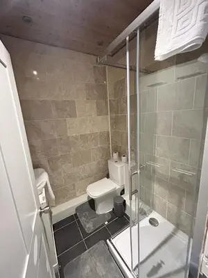 a bathroom with a toilet and a glass shower at Bethel Suite by Sasco Apartments in Blackpool