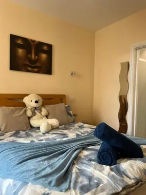 a teddy bear sitting on top of a bed at Winter Gardens Large Flat 1 in Blackpool