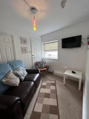 a living room with a couch and a tv at Winter Gardens Large Flat 1 in Blackpool