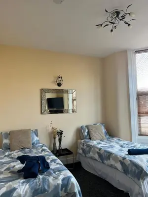a bedroom with two beds and a mirror at Winter Gardens Large Flat 1 in Blackpool