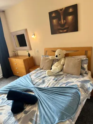 a teddy bear sitting on top of a bed at Winter Gardens Large Flat 1 in Blackpool