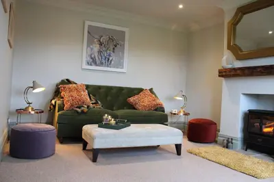 a living room with a green couch and a fireplace at Woodland Retreat in Lytham. in Lytham St Annes