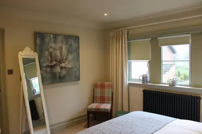 a bedroom with a bed and a window and a chair at Woodland Retreat in Lytham. in Lytham St Annes
