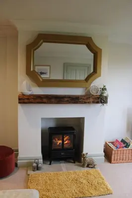 a living room with a fireplace with a mirror at Woodland Retreat in Lytham. in Lytham St Annes