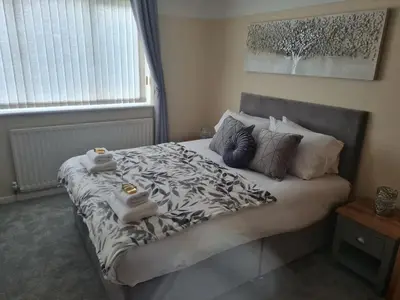 a bedroom with a large bed with towels on it at 5Bed House Wirral near Liverpool Chester in Wirral