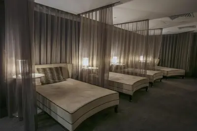 a row of beds in a room with curtains at Best Western Premier Suites Hotel & Spa Liverpool-Knowsley in Knowsley