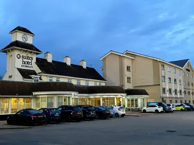 a hotel with cars parked in front of a building at Best Western Premier Suites Hotel & Spa Liverpool-Knowsley in Knowsley