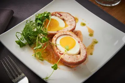 a plate of food with eggs and greens on it at Best Western Premier Suites Hotel & Spa Liverpool-Knowsley in Knowsley