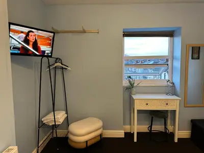 a room with a tv on a wall with a desk at Winter Gardens Flat 4 Tower view family apartment in Blackpool
