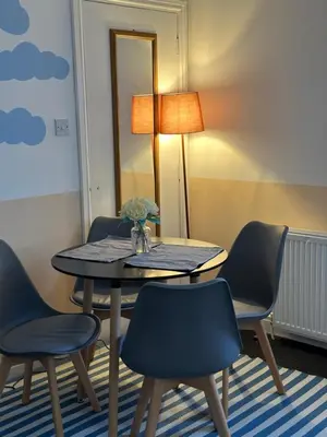 a table with chairs and a lamp in a room at Winter Gardens Flat 4 Tower view family apartment in Blackpool