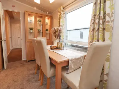 a dining room with a table and chairs and a window at Larenzo in Preston
