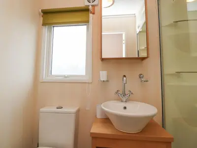 a bathroom with a sink and a toilet and a window at Larenzo in Preston