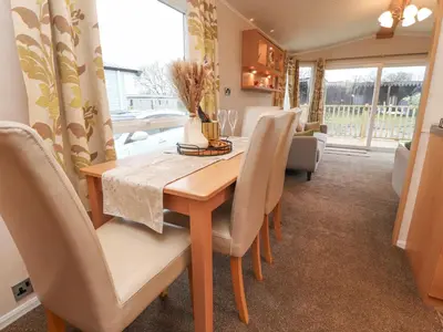 a dining room with a wooden table and chairs at Larenzo in Preston