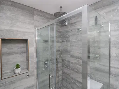a bathroom with a glass shower with a potted plant at Crag View Cottage in Barrow in Furness