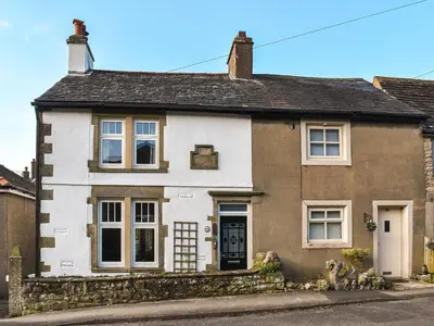 an old white and brown house on a street at Beech Cottage in Carnforth