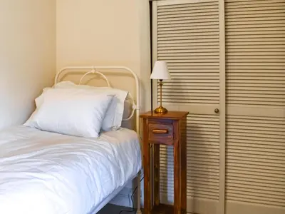 a bedroom with a bed and a table with a lamp at Beech Cottage in Carnforth