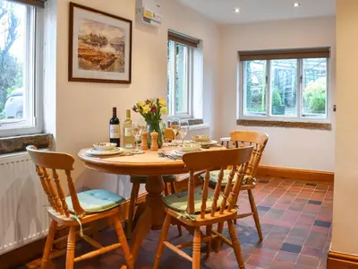 a dining room with a wooden table and chairs at Beech Cottage in Carnforth