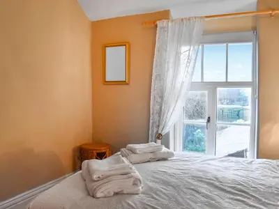 a bedroom with a bed and a window with towels at Beech Cottage in Carnforth