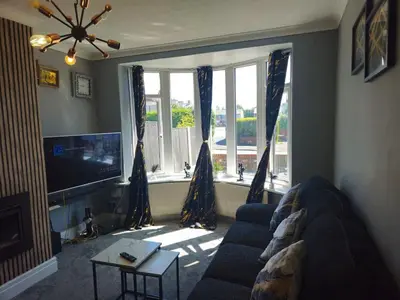 a living room with a blue couch and a large window at Aldwych house, For Holidays, Contractors & Relocation, Free Parking & Wi-Fi in Preston