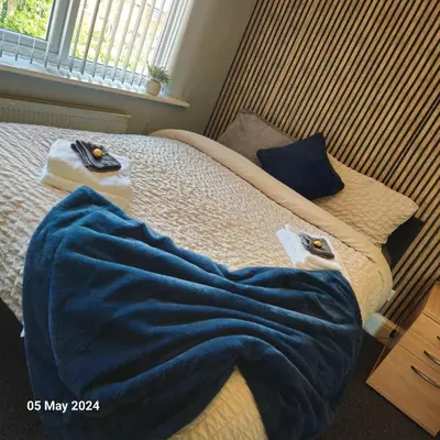 a bed with a blue blanket on top of it at Aldwych house, For Holidays, Contractors & Relocation, Free Parking & Wi-Fi in Preston