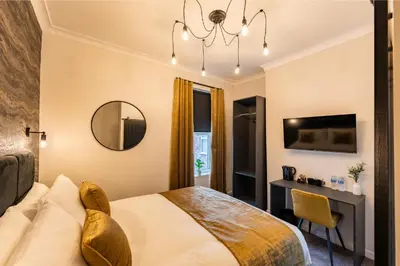 a bedroom with a bed and a desk and a mirror at Home at 42 Arkles Lane Anfield in Liverpool