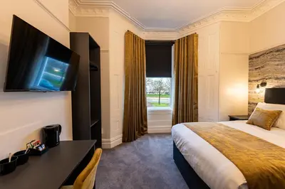 a hotel room with a bed and a television at Home at 42 Arkles Lane Anfield in Liverpool
