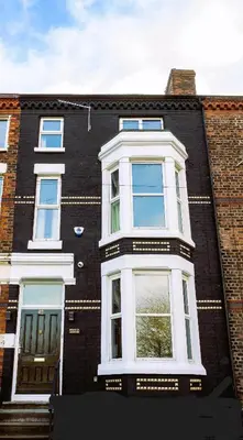 a large brick building with a white window at Home at 42 Arkles Lane Anfield in Liverpool