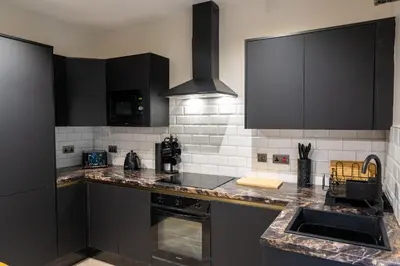 a kitchen with black cabinets and a counter top at Home at 42 Arkles Lane Anfield in Liverpool