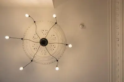 a chandelier hanging from a white wall at Home at 42 Arkles Lane Anfield in Liverpool