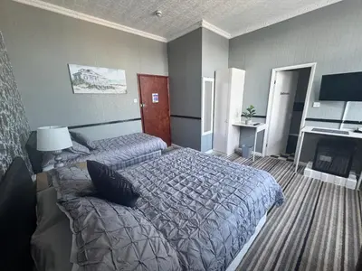 a hotel room with two beds and a fireplace at The Holmlea in Blackpool