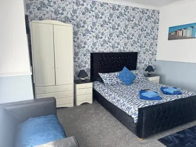 a bedroom with a bed and a cabinet and a chair at The Holmlea in Blackpool