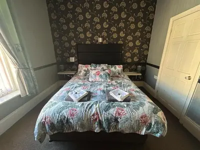 a bedroom with a bed with a floral bedspread at The Holmlea in Blackpool