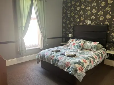 a bedroom with a bed with a floral bedspread at The Holmlea in Blackpool