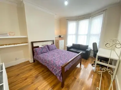 a bedroom with a bed and a couch and a chair at Cozy Retreat Haven in Liverpool