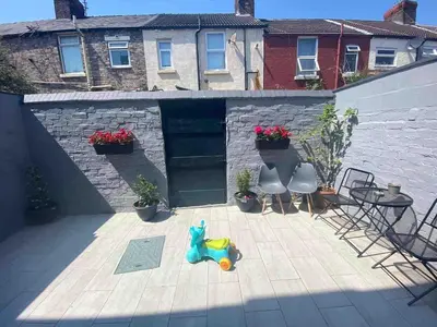 a patio with a table and chairs and a toy at Cozy Retreat Haven in Liverpool
