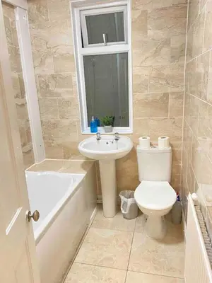 a bathroom with a toilet and a sink and a bath tub at Cozy Retreat Haven in Liverpool