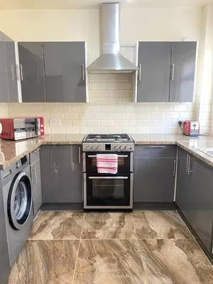 a kitchen with a stove and a washing machine at Cozy Retreat Haven in Liverpool