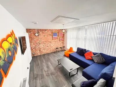 a living room with a blue couch and a brick wall at Manhattan loft Apartment by Wilom in Blackpool