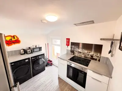 a kitchen with a stove and a washer and dryer at Manhattan loft Apartment by Wilom in Blackpool