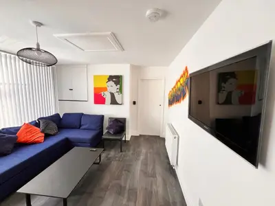 a living room with a blue couch and a flat screen tv at Manhattan loft Apartment by Wilom in Blackpool
