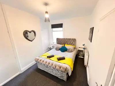 a bedroom with a bed with a yellow blanket at Manhattan loft Apartment by Wilom in Blackpool
