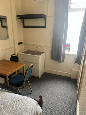 a room with a desk and a table and a bed at Apollo Number 7 in Blackpool